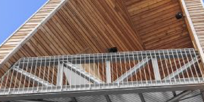 Metallgeländer an einem Balkon mit Holzverkleidung an der Decke