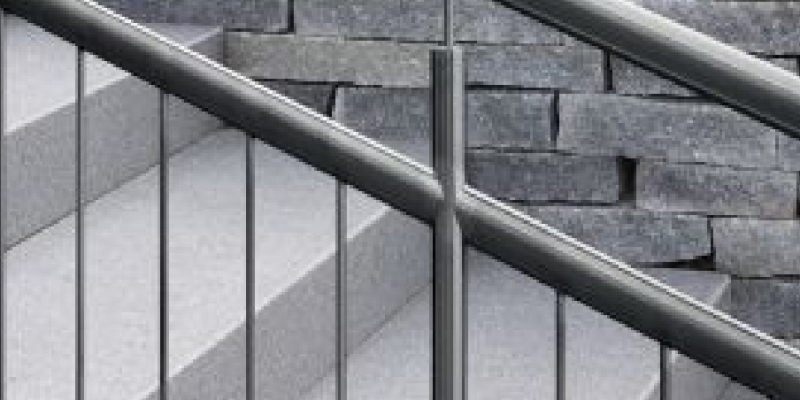 Edelstahl-Treppengeländer vor einer Natursteinwand