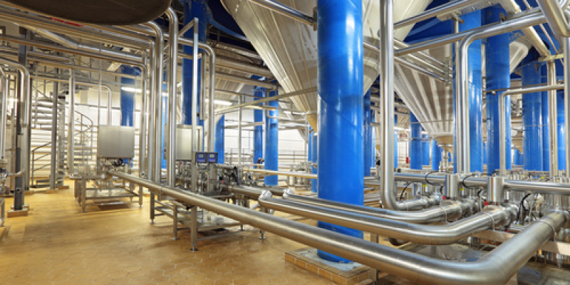 Industrieanlage mit blauen Stahlsäulen und Edelstahlrohrleitungen