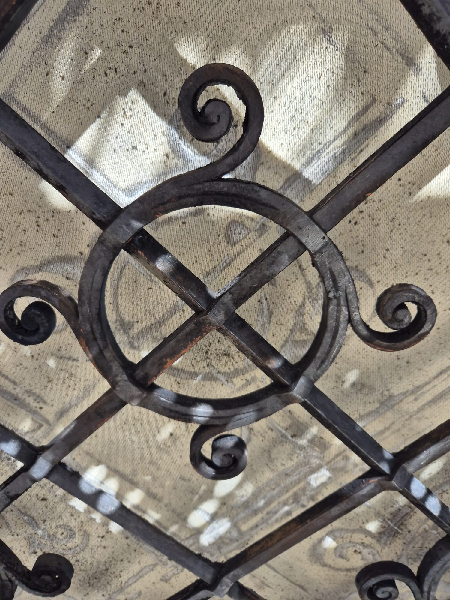 Detailaufnahme eines schmiedeeisernen Ziergitters mit Schnörkeln