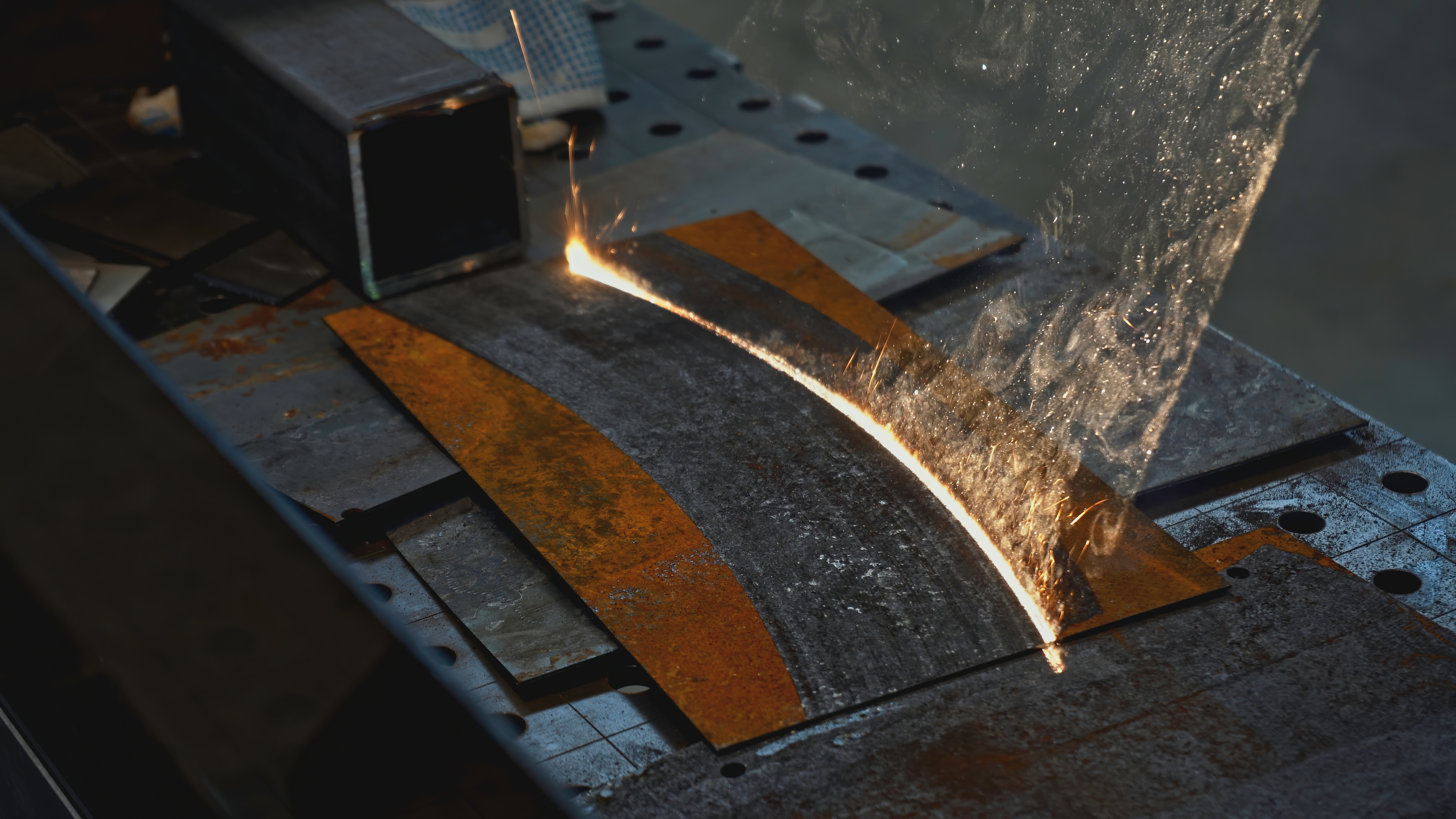 Laserreinigung entfernt Rost von einer Metalloberfläche mit Funkenflug