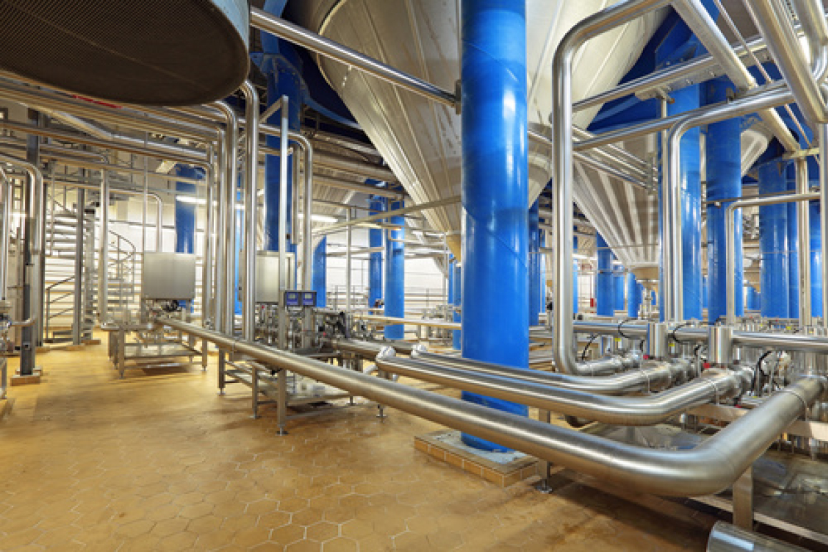 Industrieanlage mit blauen Stahlsäulen und Edelstahlrohrleitungen