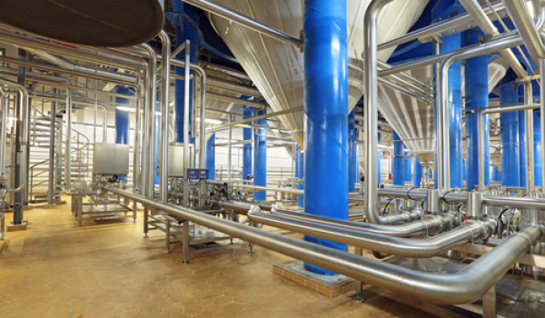 Industrieanlage mit blauen Stahlsäulen und Edelstahlrohrleitungen