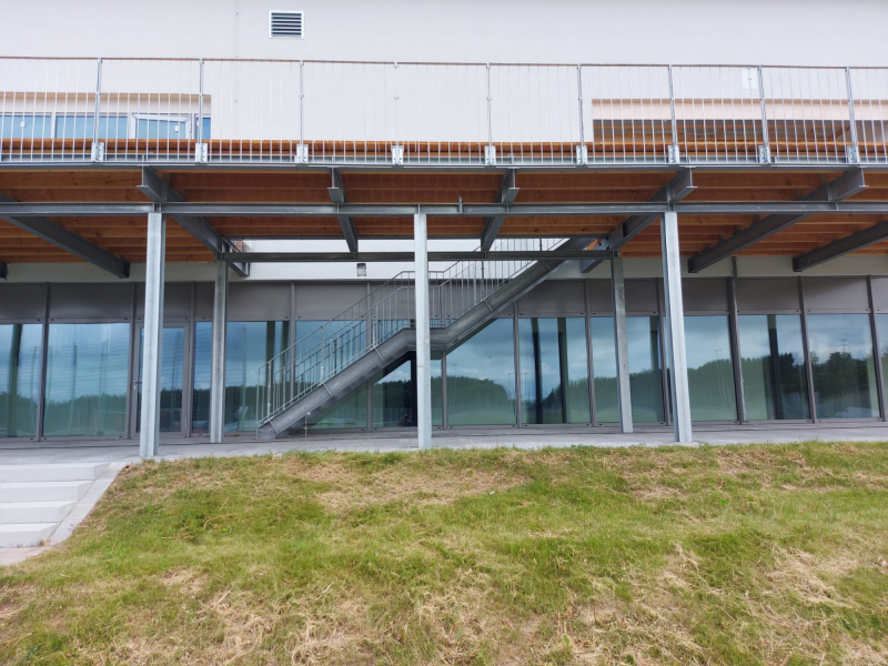 Gebäudefassade mit Stahlbalkon-Unterkonstruktion und Glasfront