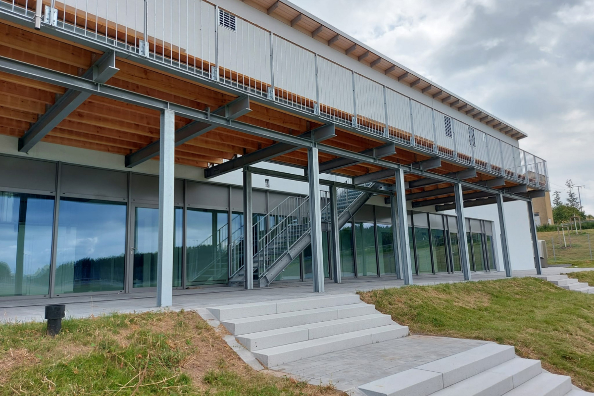 Gebäude mit Stahlbalkon-Unterkonstruktion und Holzdach