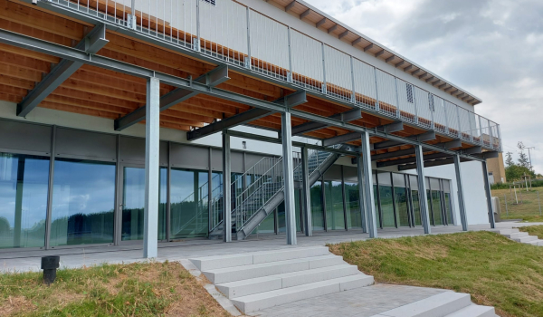 Gebäude mit Stahlbalkon-Unterkonstruktion und Holzdach