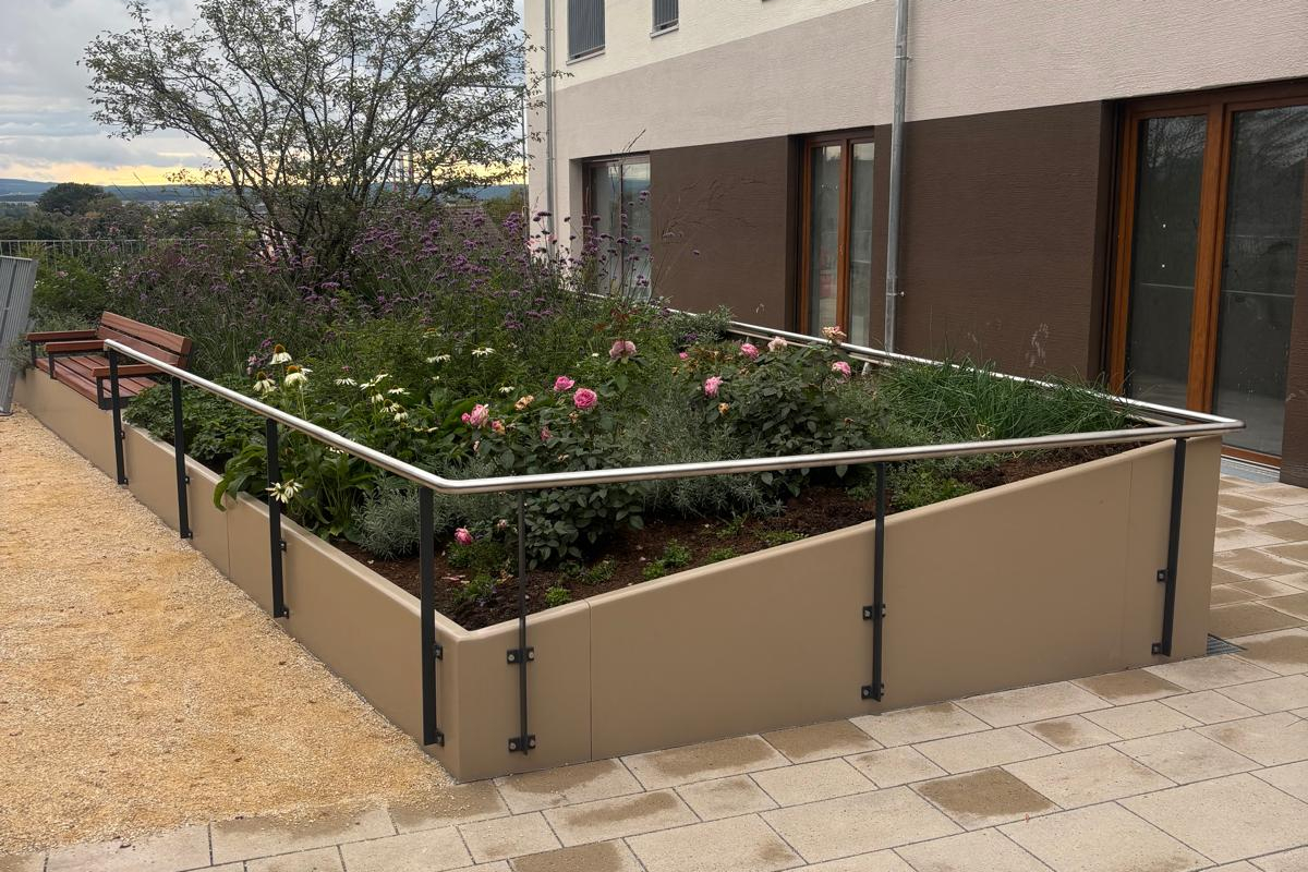 Bepflanztes Hochbeet aus Cortenstahl auf einer Terrasse