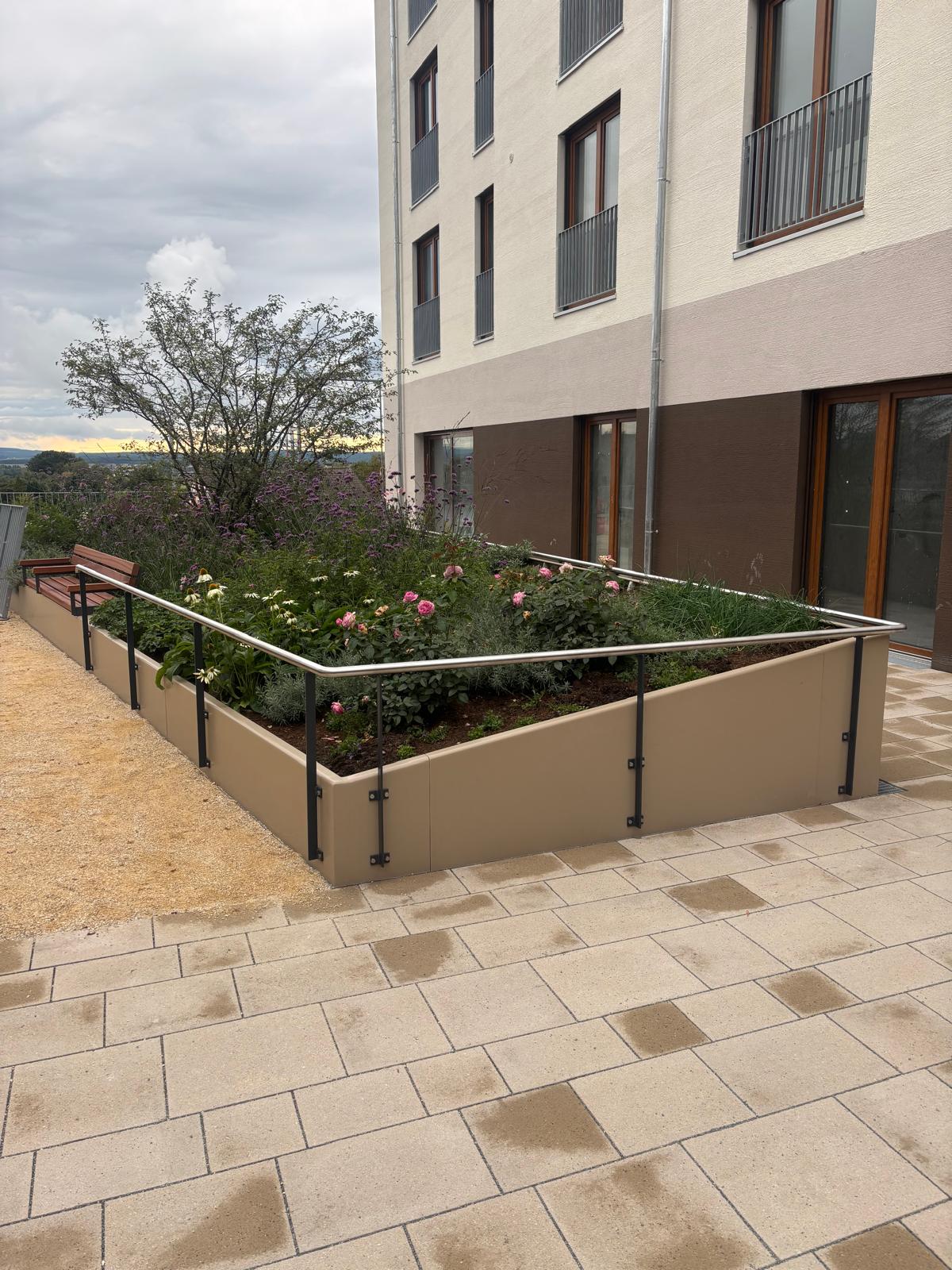 Bepflanztes Hochbeet aus Cortenstahl auf einer Terrasse