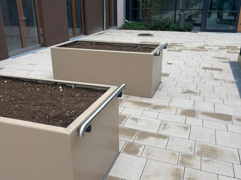 Zwei Cortenstahl-Hochbeete mit Bepflanzung auf einer Holzterrasse