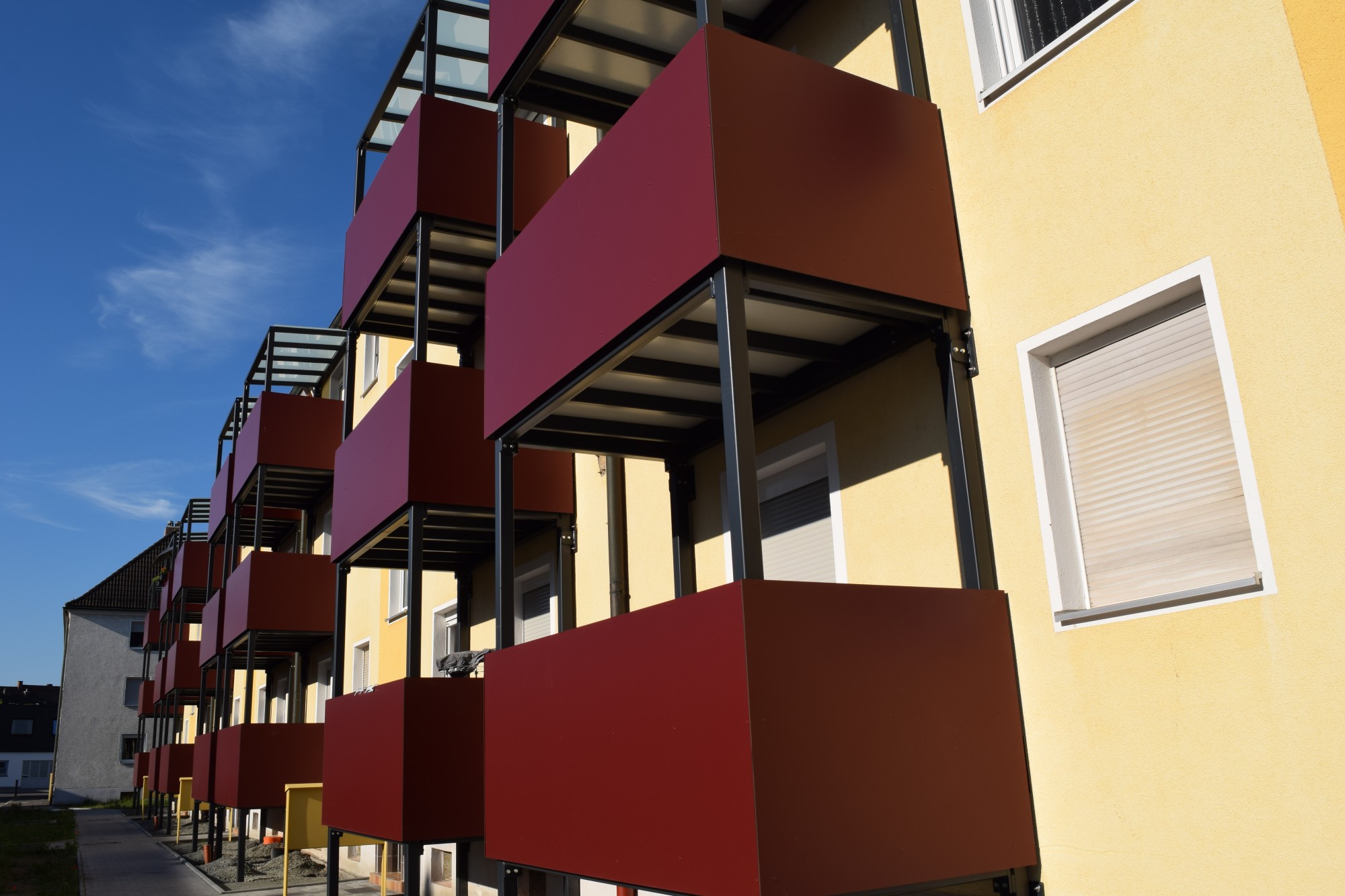 Rote Balkonverkleidungen an einem Mehrfamilienhaus