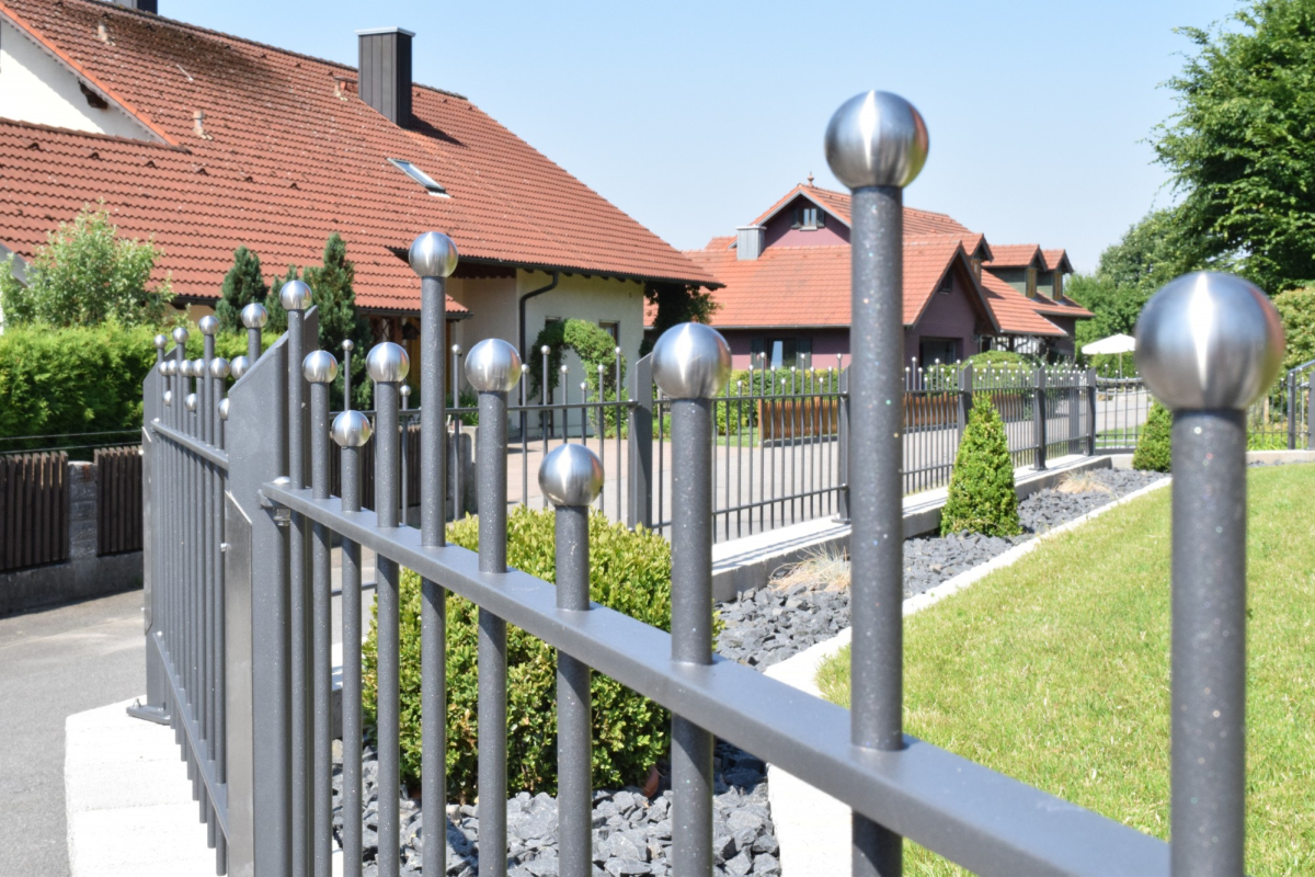 Metallzaun mit Edelstahlkugeln und geschwungenen Querstreben