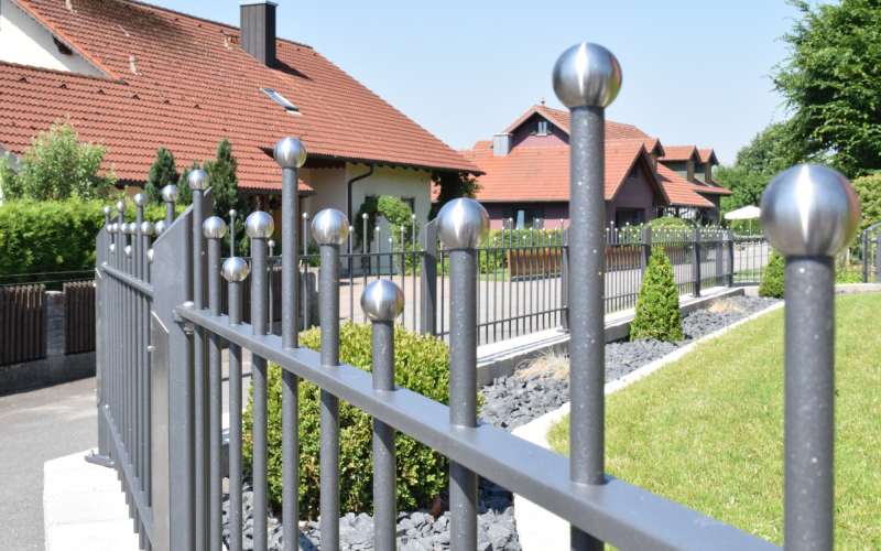 Metallzaun mit Edelstahlkugeln und geschwungenen Querstreben