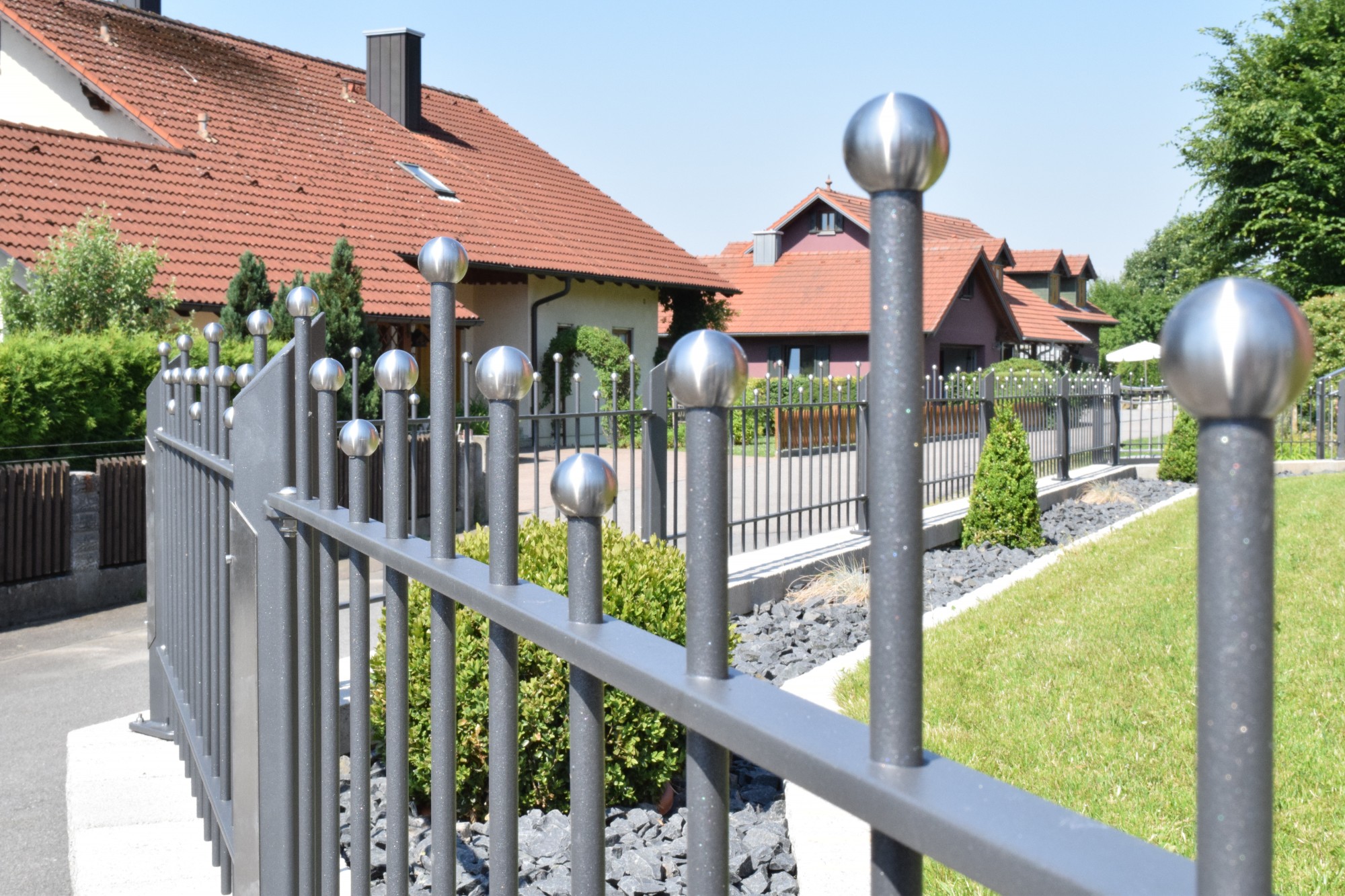 Metallzaun mit Edelstahlkugeln und geschwungenen Querstreben