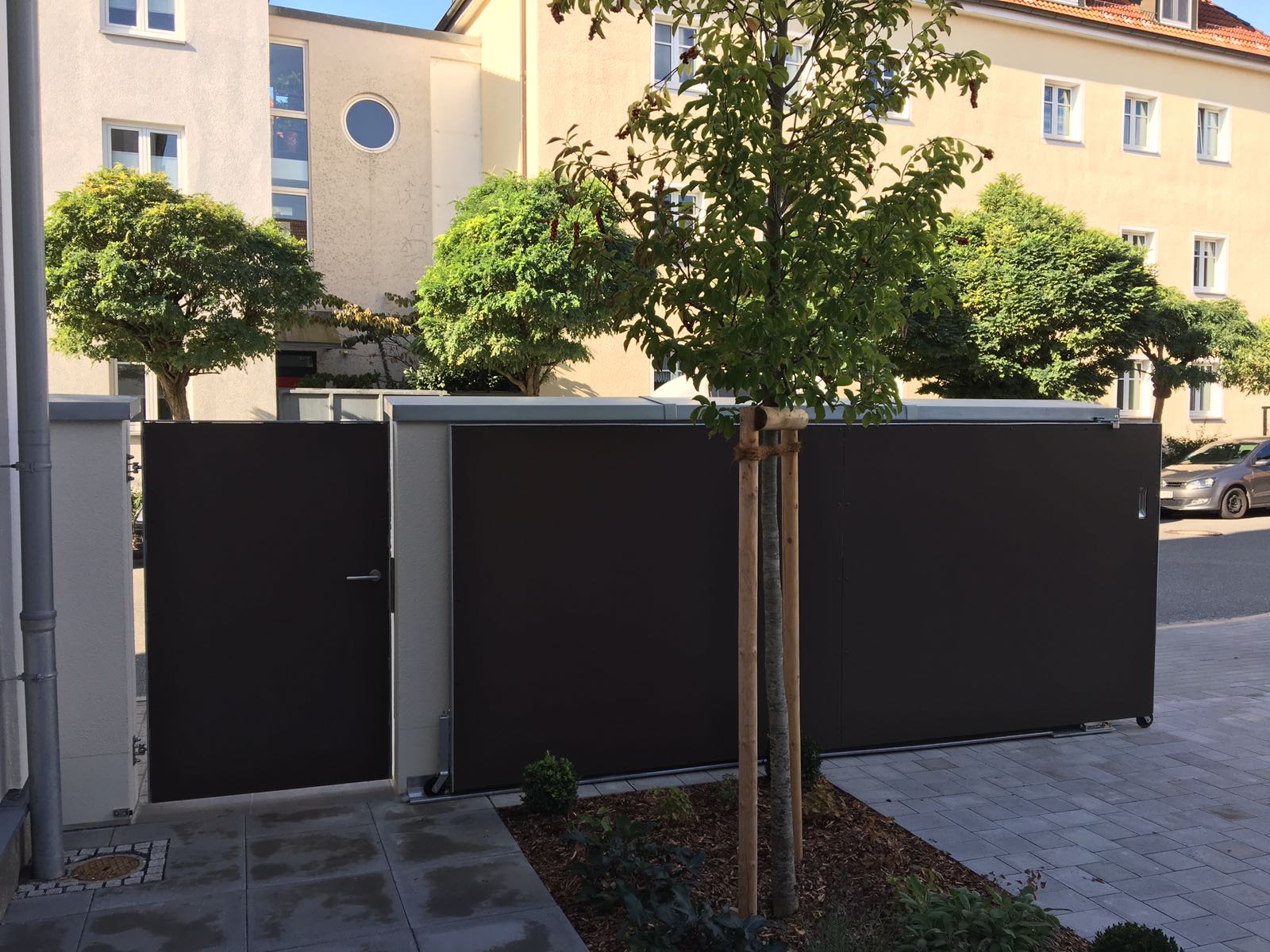 Anthrazitfarbene Sichtschutzelemente mit Bäumen davor