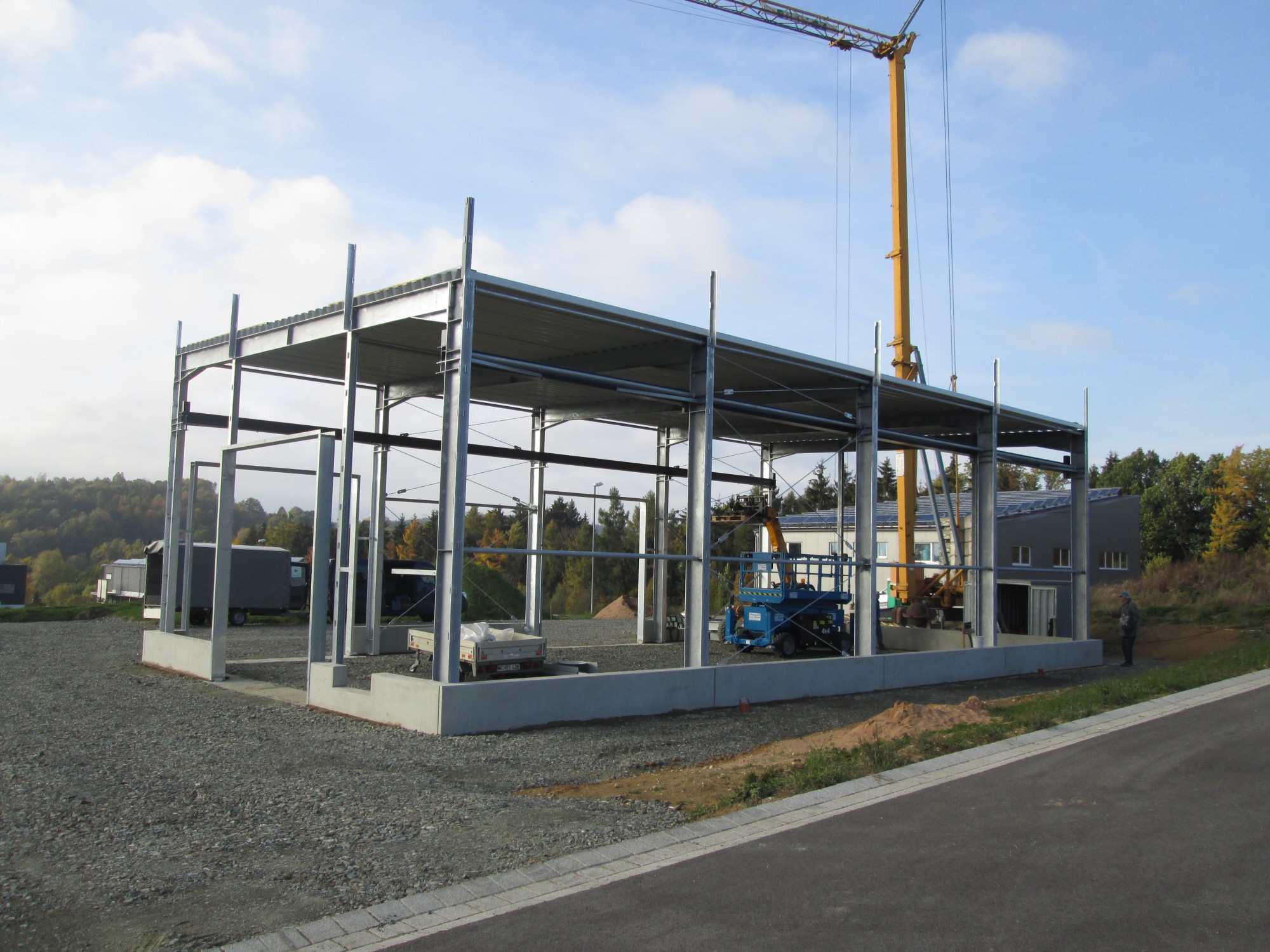 Stahlkonstruktion der Werkhalle im Rohbau mit Baukran