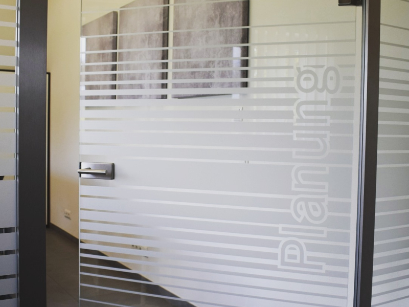 Glastür mit Aufschrift Planung und Sichtschutzfolierung